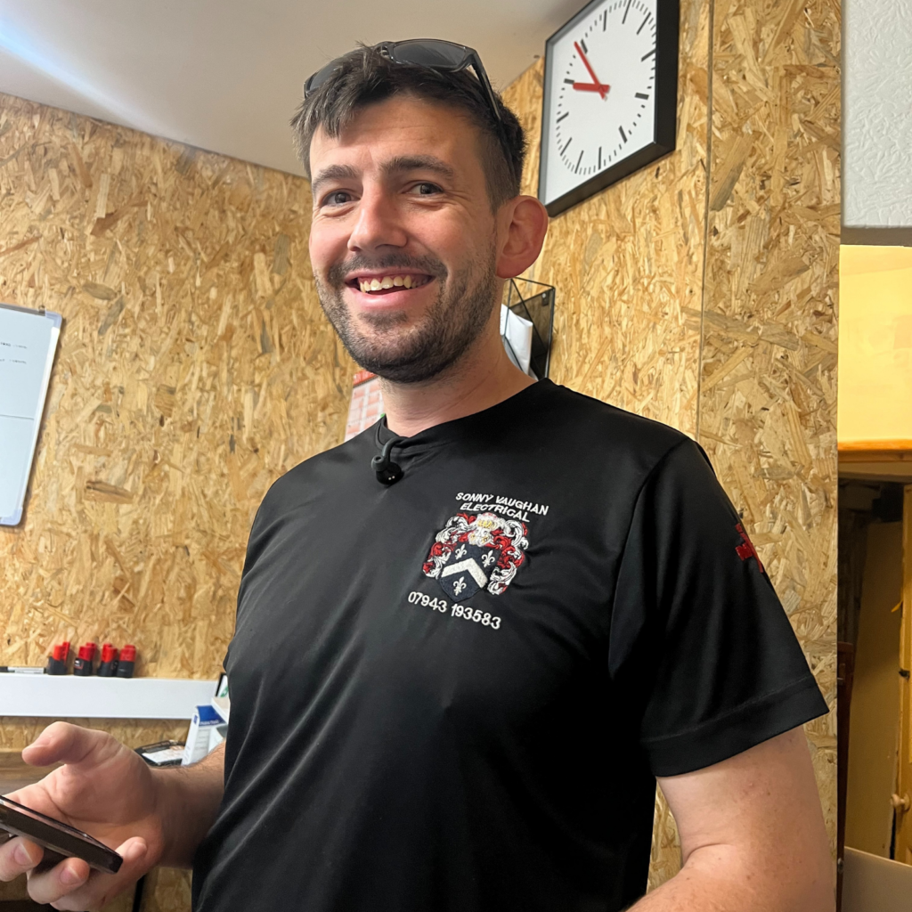 Smiling electrician in Sonny Vaughan Electrical office.