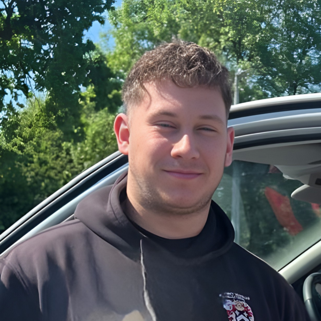 Headshot of electrician with short brown in black Sonny Vaughan Electrical hoodie, smiling at the camera.
