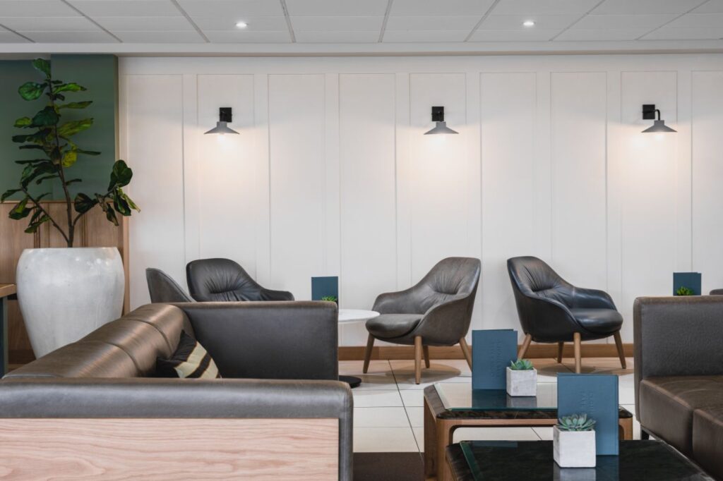 Modern hotel restaurant with leather chairs and white lighting.