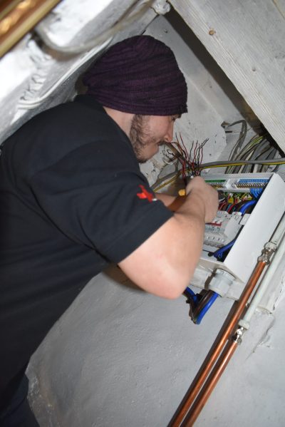 A zoomed in image of an electrician in Sonny Vaughan Electrical uniform changing a distribution board.
